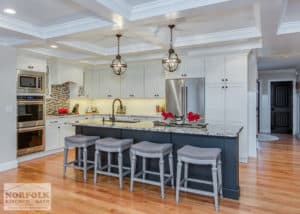 white kitchen with black island and hardwood floors