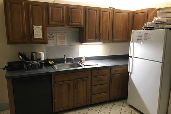 old kitchen cabinets with appliances at the Pine Street Inn Yearwood House in Boston, MA