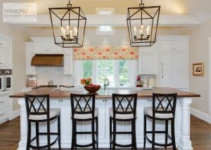 back side of white island showing large candle type decorative pendant lights over island